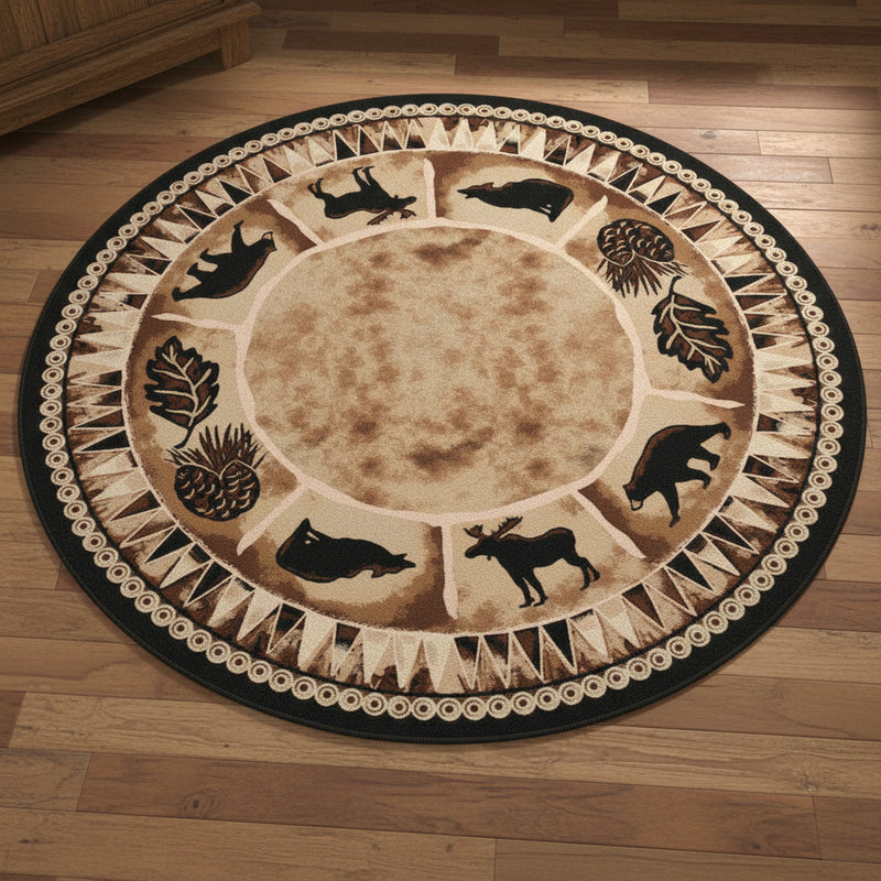 A round area rug with a rustic woodland theme, featuring black silhouettes of various deer, bears, and a moose around a tan center, surrounded by pinecones and leaves, and finished with a black and beige patterned border.