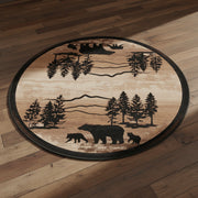 Mountain Dusk Bear Family round rug with bear, deer, and pine tree silhouettes on a hardwood floor.