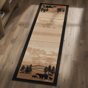 A long rectangular area rug with a natural wood grain texture in warm tan and brown tones, featuring black silhouetted forest and mountain motifs at the top and bottom.