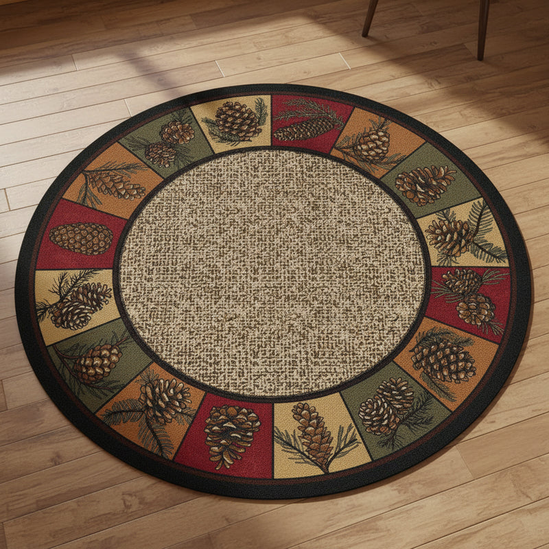 Round area rug with a natural jute-textured center and a decorative border featuring pinecones, pine branches, and geometric panels in red, tan, olive green, and black.