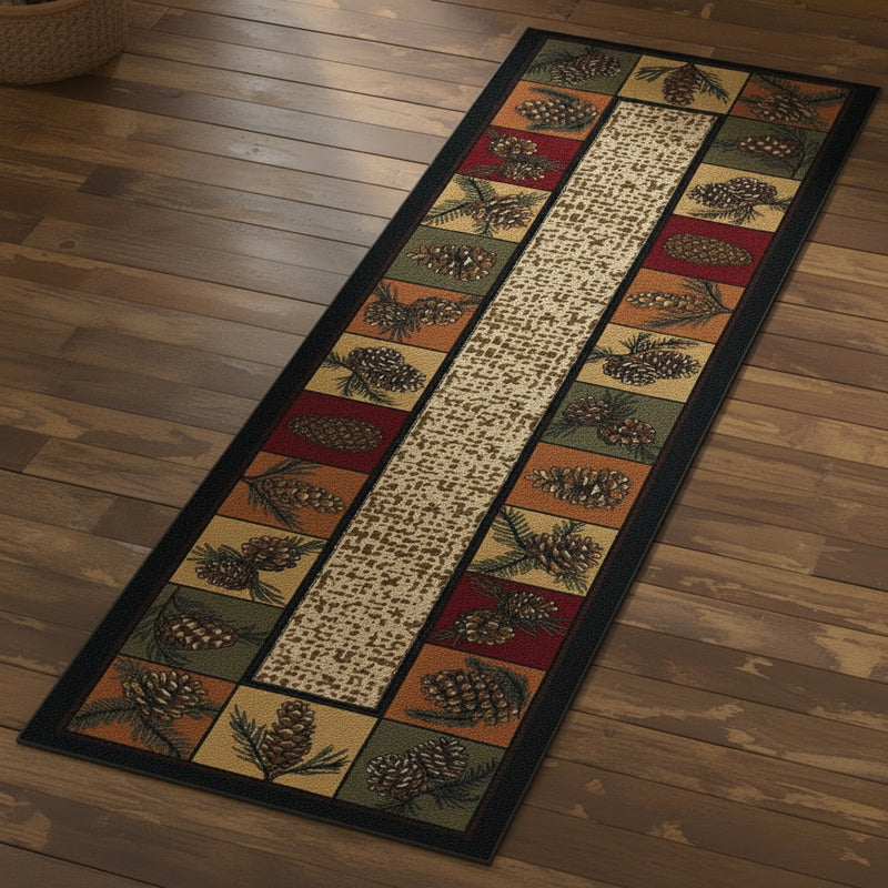 A rectangular area rug with a rustic pinecone and leaf pattern, featuring a central vertical stripe of beige script text and bordered side panels in dark green, rust red, and tan. 