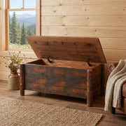 Atlantic Peak Barnwood Blanket Chest with the lid open at the foot of a bed in a pine-walled bedroom