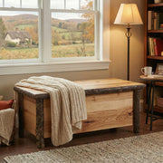 Bison Peak Hickory Log Blanket Chest in Natural with a folded blanket beside a floor lamp and armchair