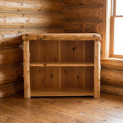 Bross Peak Cedar Log Open Bookcase staged in a sunlit log cabin living room