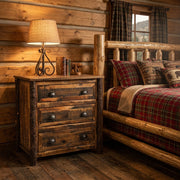 Clinton Peak Barnwood Nightstand with a glowing lamp beside a log bed and plaid quilt in a pine log cabin