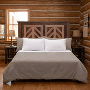 Columbia Point Reclaimed Barnwood Chevron Headboard staged in a sunlit log cabin bedroom