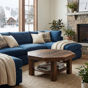 Comanche Peak Reclaimed Barnwood Octagon Coffee Table in front of a blue sectional and stone fireplace