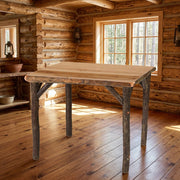 Coxcomb Peak Hickory Log Square Dining Table staged in a sunlit log cabin dining room