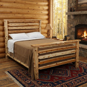 Crestone Peak Cedar Log Bed staged in a pine log lodge bedroom with stone fireplace, aspen window view, and wool rug
