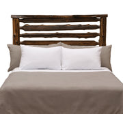 Front view of the Grizzly Peak Cedar Live Edge Headboard in coffee stain styled with white pillows and gray bedding