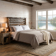 Grizzly Peak Cedar Live Edge Headboard in a whitewashed lakeside cabin bedroom with a lamp nightstand and lake view window