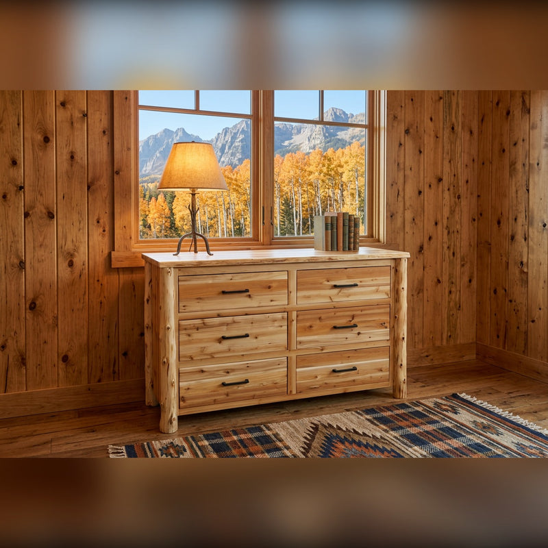 Hagerman Peak Cedar Log Dresser with a lamp and books below a window framing golden aspens and mountains in a knotty pine lodge room
