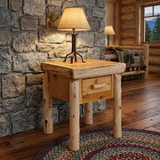 James Peak Cedar Log Nightstand with an iron lamp against a stone wall on a braided rug in a lodge bedroom