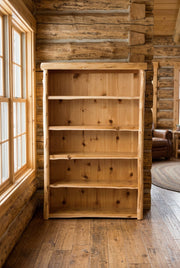 Jones Mountain Cedar Log Library Bookcase staged in a sunlit log cabin living room