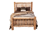 Front view of the Maroon Bells Cedar Log Spindle Bed styled with striped wool bedding and pillows