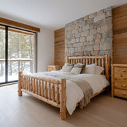 Maroon Bells Cedar Log Spindle Bed in a bright modern cabin bedroom with a stone accent wall and lake view