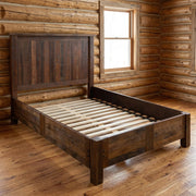 Medano Peak Reclaimed Barnwood Panel Bed with Rail System staged in a sunlit log cabin bedroom