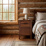 Mount Axtell Live Edge Walnut Enclosed Nightstand staged in a sunlit log cabin bedroom
