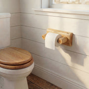Wall-mounted Mount Cairns Cedar Log Toilet Paper Holder with spring roller in a rustic bathroom