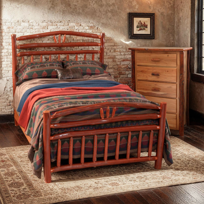 Mount Columbia Hickory Wagon Wheel Bed with a red striped blanket beside a pine dresser in a rustic bedroom with a stone wall
