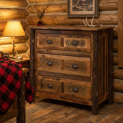 Mount Eva Barnwood and Hickory Chest of Drawers beside a buffalo plaid bed in a lamplit log cabin bedroom