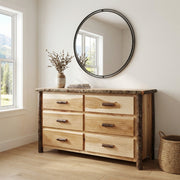Mount Jackson Hickory Log Dresser in Natural below a round mirror with a vase of dried stems in a white bedroom