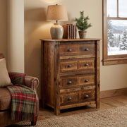 Mount Tweto Reclaimed Barnwood Chest of Drawers with a lamp and small pine tree on top beside a plaid armchair in a cozy bedroom