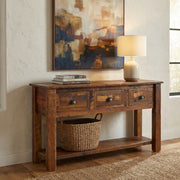 Notchtop Mountain Reclaimed Barnwood Three Drawer Console Table with a lamp and woven basket in a bright entryway