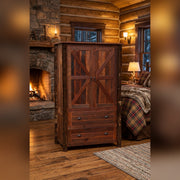 Pagoda Mountain Barnwood and Hickory Wardrobe staged in a log cabin bedroom beside a stone fireplace and plaid bed