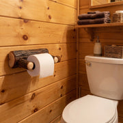 Wall-mounted Pearl Mountain Hickory Log Toilet Paper Holder in a rustic bathroom