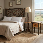 Precipice Peak Hickory Log Floor Lamp with side shelf beside a chair