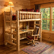 Rabbit Ears Cedar Log Loft Bed staged over a desk in a knotty pine cabin bedroom with a braided rug and forest window