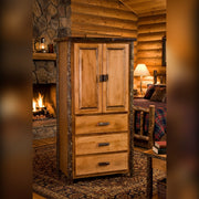 Taylor Peak Hickory Log Armoire beside a stone fireplace in a log cabin bedroom