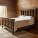 Telluride reclaimed barnwood post bed in a rustic mountain cabin bedroom with natural wood finishes and warm lighting