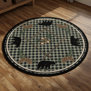 A circular rustic-themed rug or mat featuring a black and gray buffalo plaid background with black bear silhouettes, pinecones, acorns, and crossed wooden poles arranged symmetrically.