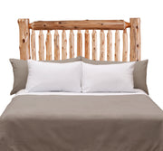 Front view of the Torreys Peak Cedar Log Spindle Headboard styled with white pillows and gray bedding